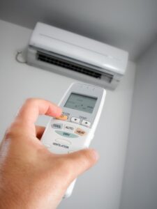 hand-holding-remote-in-front-of-ductless-wall-air-handler
